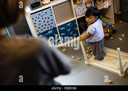 Maman regarde son enfant a fait Un désordre dans la salle, fond pour la publicité et le papier peint dans l'éducation et la scène de style de vie. Banque D'Images