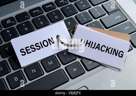 Texte de détournement de session sur bloc-notes blanc avec fond de clavier d'ordinateur portable. Concept d'activité hacker et arnaque Banque D'Images