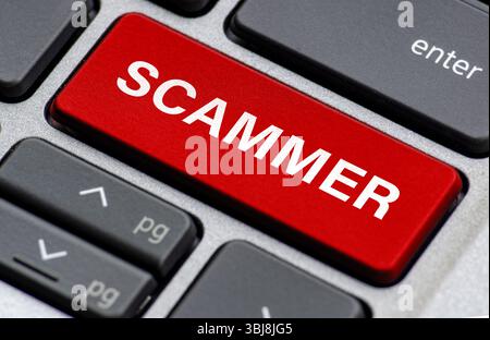 Texte d'escroc sur le clavier d'ordinateur portable indiquant où les utilisateurs sont attachés par escroc Banque D'Images