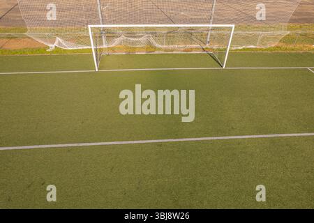 vue aérienne d'un but de football vide sur un terrain de gazon artificiel vert, vue aérienne par drone Banque D'Images