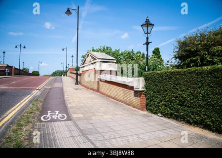Symbole de vélo peint sur le trottoir au début d'une piste cyclable près de l'entrée du pont d'Enfield Island Village, Londres. Banque D'Images