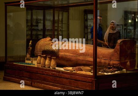 Le Caire, Égypte - 11 septembre 2023 : un ancien sarcophage exposé dans un musée entouré d'artefacts et de visiteurs le regardant. Banque D'Images
