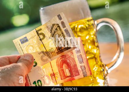 Bierpreis steigt, Mass Bier kostet durchschnittlich 15 Euro beim Oktoberfest 2025, Symbolfoto, München, Juni 2025 Deutschland, München, Juni 2025, Symbolfoto Bierpreise steigen, eine Maß Bier wird auf dem Oktoberfest 2025 durchschnittlich um 3,52 Prozent teurer gegenüber 2024, Preise reichen künftig von 14,50 Euro und 15,80 Euro für einen Liter Bier, Symbolbild Mass Bier in einem Biergarten, 15 Euro als Bezahlung in der Hand, Helles, Außengastro, bayerisch, Bayern, *** le prix de la bière augmente, la bière de masse coûte en moyenne 15 euros à Oktoberfest 2025, photo symbolique, Munich, juin 2025 Allemagne, Munic Banque D'Images