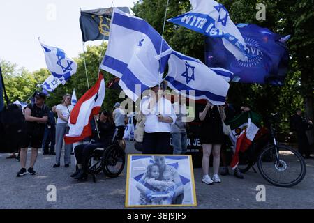 Berlin, Allemagne. 14 juin 2025. Les gens manifestent avec des drapeaux israéliens et une photo d'otages israéliens enlevés et tués lors d'un rassemblement organisé par l'initiative "solidarité avec Israël". Crédit : Carsten Koall/dpa/Alamy Live News Banque D'Images
