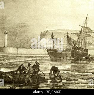 Whitby Yorkshire dans le passé - pêcheurs déchargeant des marchandises des navires échoués sur Whitby Beach. Banque D'Images