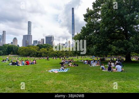 Des gens assis sur l'herbe à Central Park à New York, USA, le 21 août 2022 Banque D'Images