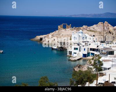 Firopotamos sur l'île de Milos avec des maisons blanches et des cadres de fenêtres bleus par l'eau turquoise calme sous ciel bleu clair. Un village paisible des Cyclades. Banque D'Images