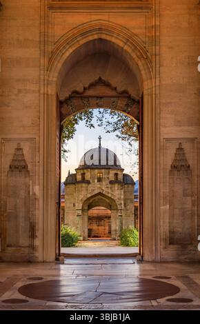Les arches de la cour de la mosquée Suleymaniye menant à un dôme intérieur serein, éclairé par la douce lumière du coucher de soleil à Istanbul, Turquie Banque D'Images