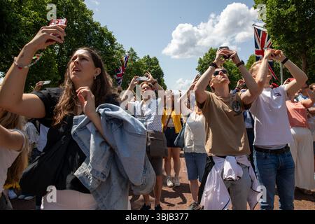 Londres, Royaume-Uni, 14 juin 2025. Les membres du public prennent des photos sur leurs téléphones portables du survol au Trooping of the Colour. Des milliers de membres du public assistent au Trooping the Colour annuel. Organisé pour commémorer l’anniversaire officiel du souverain, des membres de la famille royale britannique et des milliers d’invités. Une fois terminé, les membres du public remplissent le Mall pour assister à un flypast militaire et saluer la famille royale alors qu'ils s'adressent à la foule depuis un balcon au palais de Buckingham. Crédit : James Willoughby/ALAMY Banque D'Images