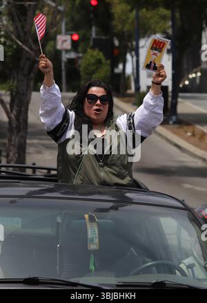San Francisco, États-Unis. 14 juin 2025. Une femme agite un drapeau et une pancarte soutenant les manifestants "No Kings" à San Francisco, Californie, le samedi 14 juin 2025. Des manifestations « No Kings » ont eu lieu dans tout les États-Unis pour contrer le défilé militaire du président Donald Trump à Washington, DC. Photo de George Nikitin/UPI crédit : UPI/Alamy Live News Banque D'Images
