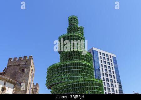 Sculpture contemporaine faite de bouteilles devant l'architecture moderne et historique sous un ciel dégagé, Gijon, Asturies, Espagne, Europe Banque D'Images