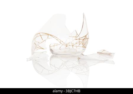 Verre vide cassé isolé sur fond blanc avec réflexion, concept de chance Banque D'Images