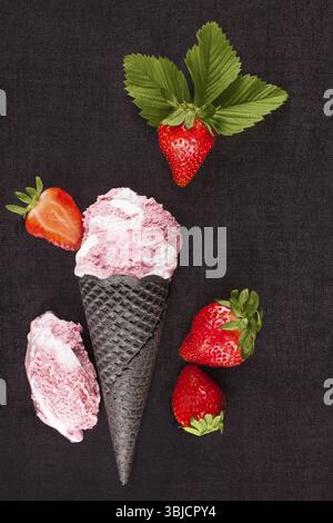 Crème glacée aux fraises avec des fraises rouges fraîches mûres d'en haut sur une surface sombre Banque D'Images
