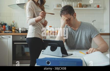 L'homme fatigué de l'auto-isolement travaille à la maison. Confinement du coronavirus Banque D'Images