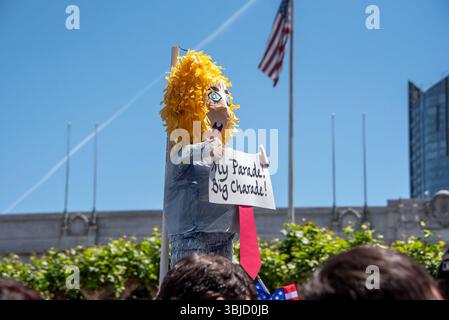 San Francisco, États-Unis. 14 juin 2025. Au-dessus des manifestants rassemblés pour l'événement No Kings Day à San Francisco, une effigie de Donald Trump portant une longue cravate rouge et tenant une pancarte indiquant : « ma parade ? Grande charade !' est maintenu haut. Le défilé militaire de Trump est prévu plus tard dans la journée. Crédit : Shelly Rivoli/Alamy Live News Banque D'Images