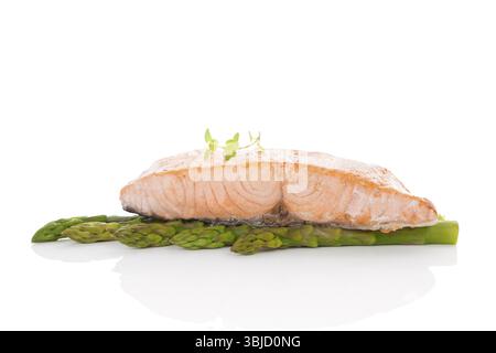 Délicieux steak de saumon sur asperges vertes isolé sur fond blanc. Fruits de mer culinaires Banque D'Images