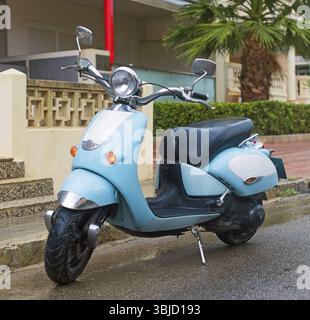 Scooter bleu garé dans la rue Banque D'Images