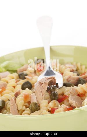 Salade de thon avec morceaux de thon, câpres et fusilli dans un bol vert. Morceau de thon sur fourchette. Manger culinaire Banque D'Images