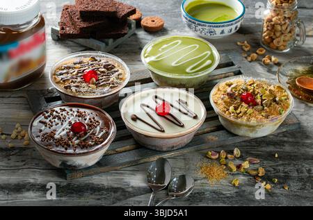 Une collection de desserts froids orientaux et occidentaux : crème glacée kunafa, dessert pistache, mousse Nutella, mousse au chocolat et au caramel. Banque D'Images