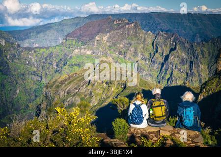 Heureux amis âgés assis dans les montagnes. Randonneurs plus âgés avec sac à dos se relaxant près du pic Pico do Areeiro et profitant de la belle vue, Madère Banque D'Images