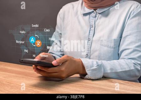 Une femme utilisant un smartphone pour traduire différentes langues. Concept de traduction multilingue. Banque D'Images