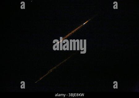 Naplouse, Palestine. 14 juin 2025. Des roquettes tirées depuis l'Iran sont aperçues la nuit au-dessus du ciel en Cisjordanie occupée. Israël et l'Iran ont échangé des tirs ; quelques jours après qu'Israël a lancé une campagne de frappes aériennes sans précédent qui, selon l'Iran, a frappé ses installations nucléaires, a "martyrisé" des hauts commandants et a tué des dizaines de civils. Crédit : SOPA images Limited/Alamy Live News Banque D'Images