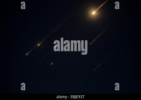 Naplouse, Palestine. 14 juin 2025. Des roquettes tirées depuis l'Iran sont aperçues la nuit au-dessus du ciel en Cisjordanie occupée. Israël et l'Iran ont échangé des tirs ; quelques jours après qu'Israël a lancé une campagne de frappes aériennes sans précédent qui, selon l'Iran, a frappé ses installations nucléaires, a "martyrisé" des hauts commandants et a tué des dizaines de civils. (Photo de Nasser Ishtayeh/SOPA images/Sipa USA) crédit : Sipa USA/Alamy Live News Banque D'Images
