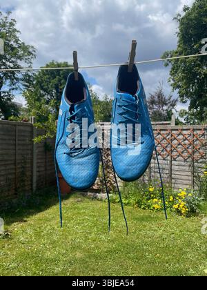 chaussures de football adidas messi colorées bleues suspendues à une ligne de lavage à londres en angleterre Banque D'Images