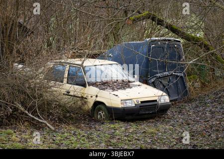PETRVALD, RÉPUBLIQUE TCHÈQUE - 26 JANVIER 2024 : épave de la Skoda Favorit 136L jaune tchèque garée dans la brousse Banque D'Images