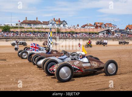 Une course se déroule pendant la course The Waves 2025 sur la plage sud de Bridlington dans le Yorkshire. L'événement unique du calendrier automobile britannique verra des voitures et des vélos classiques courir les vagues le long de la plage South Beach de Bridlington par paires depuis un départ marqué. Date de la photo : dimanche 15 juin 2025. C'est un hommage à des temps passés, où les plages du Yorkshire ont été les premiers terrains d'essai pour les tentatives de record de vitesse terrestre au Royaume-Uni. Les véhicules effectuent des « courses de dragsters animées » par paires sur un parcours de 200 mètres marqué dans le sable frais de marée. Le crédit photo devrait se lire : Danny Lawson/PA Wire Banque D'Images