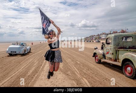 Une course se déroule pendant la course The Waves 2025 sur la plage sud de Bridlington dans le Yorkshire. L'événement unique du calendrier automobile britannique verra des voitures et des vélos classiques courir les vagues le long de la plage South Beach de Bridlington par paires depuis un départ marqué. Date de la photo : dimanche 15 juin 2025. C'est un hommage à des temps passés, où les plages du Yorkshire ont été les premiers terrains d'essai pour les tentatives de record de vitesse terrestre au Royaume-Uni. Les véhicules effectuent des « courses de dragsters animées » par paires sur un parcours de 200 mètres marqué dans le sable frais de marée. Le crédit photo devrait se lire : Danny Lawson/PA Wire Banque D'Images
