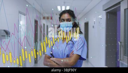 Infirmière debout portant des gommages bleus regardant les cartes de santé dans le couloir de l'hôpital, avec stéthoscope Banque D'Images