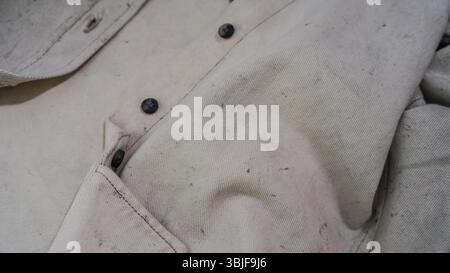 Gros plan de chemise textile beige clair avec motif moucheté et détails de bouton Banque D'Images