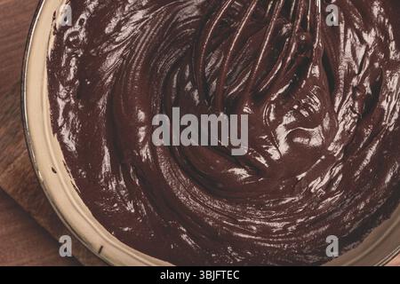 Un bol de pâte au chocolat, un fouet pour fouetter, cuire au four, structure et consistance, fait maison, vue de dessus, personne Banque D'Images