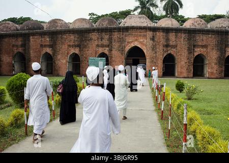 Les fidèles marchent vers la Mosquée historique Sixty Dome à Bagerhat, au Bangladesh, un site classé au XVe siècle au patrimoine mondial de l'UNESCO. Banque D'Images