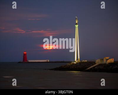Lever de lune entre le phare de Poolbeg et notre Dame étoile de la mer Banque D'Images