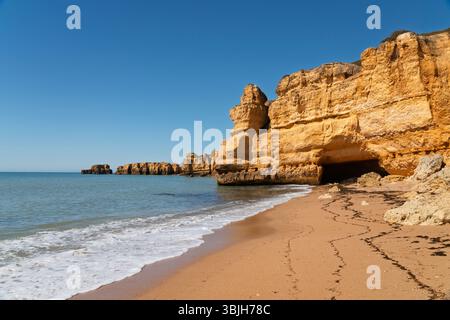 Formations rocheuses côtières et piles marines sur la plage de Castelo, Algarve, Portugal, Europe. Banque D'Images