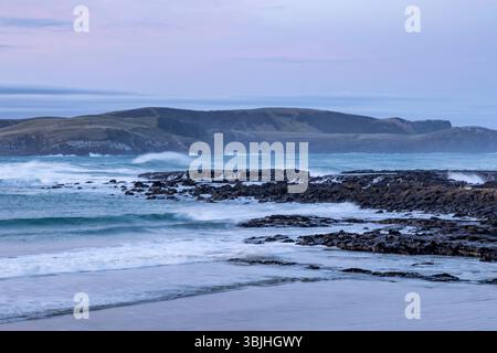 Porpoise Bay sur la côte Catlins de l'île du Sud, Nouvelle-Zélande, lever de soleil sur la côte sauvage et accidentée Banque D'Images