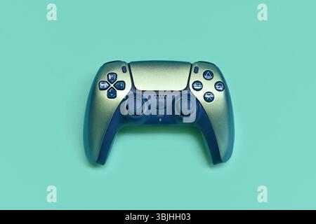 Allemagne - mai 2025 : manette PlayStation 5 sans fil DualSense de Sony en couleur sarcelle chromée sur fond turquoise Banque D'Images