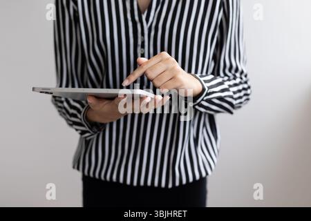 Gros plan de mains féminines touchant une tablette numérique. Gros plan des mains d'une personne à l'aide d'une tablette numérique. Banque D'Images