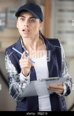 portrait d'une travailleuse parlante tenant un presse-papiers Banque D'Images