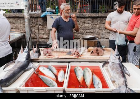 Un vendeur d'espadon frais sur un marché aux poissons en Sicile Banque D'Images