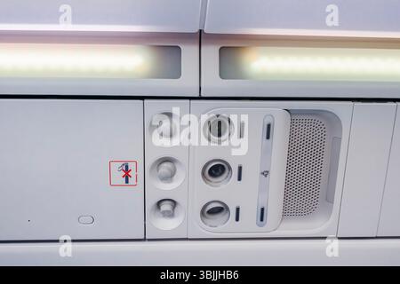 Gros plan de l'unité de service passagers de l'avion avec panneau « interdiction de fumer ». Aviation commerciale, détail intérieur de la cabine, caractéristiques de sécurité, technologie de transport aérien Banque D'Images