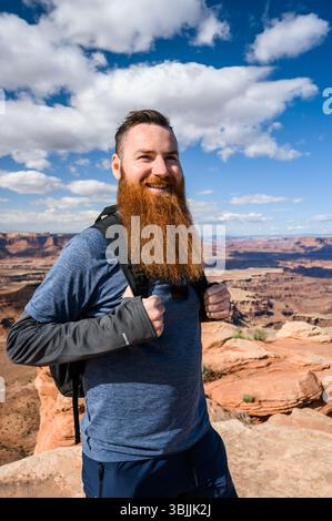 Homme barbu souriant, randonnée dans le parc national de Canyonlands, Utah Banque D'Images
