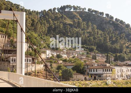 Berat, Albanie 5-07-2024 : paysage urbain historique de Berat avec des maisons ottomanes blanches escaladant la colline, des rues en pierre et la montagne en toile de fond Banque D'Images