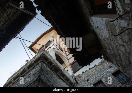 Berat, Albanie 5-07-2024 : paysage urbain historique de Berat avec des maisons ottomanes blanches escaladant la colline, des rues en pierre et la montagne en toile de fond Banque D'Images