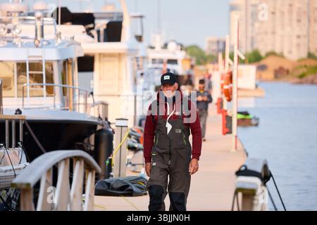 Russie, St.Petersburg, 08 juin 2025 : un yachtsman marche le long de la jetée, Un yacht club au coucher du soleil, des yachts et des voiliers sont amarrés aux couchettes, énorme Banque D'Images