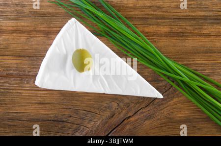 Camembert au fromage, olives et oignon vert sur une vieille table en bois. Vue de dessus Banque D'Images