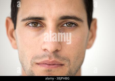 Gros plan portrait beau visage jeune homme regardant la caméra Banque D'Images