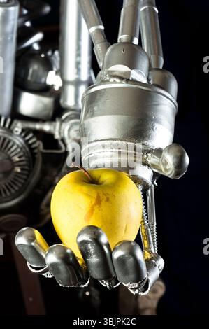 Une main de robot avec une pomme verte Banque D'Images